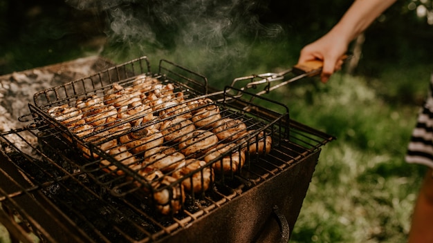 Witte identieke kleine ronde champignons champignons gestapeld in even rijen in een barbecue op de grill.