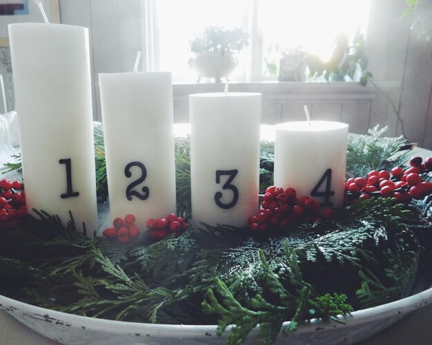 Foto witte kaarsen met cijfers op tafel.