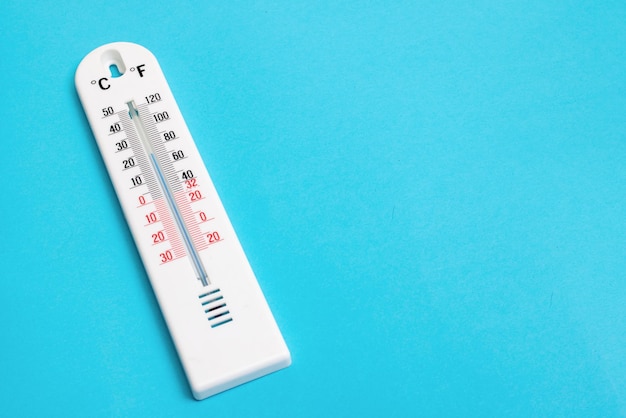 Witte kamerthermometer op een blauwe achtergrond