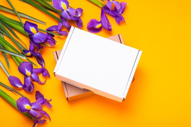Witte kartonnen kartonnen doos verfraaid met verse irisbloemen