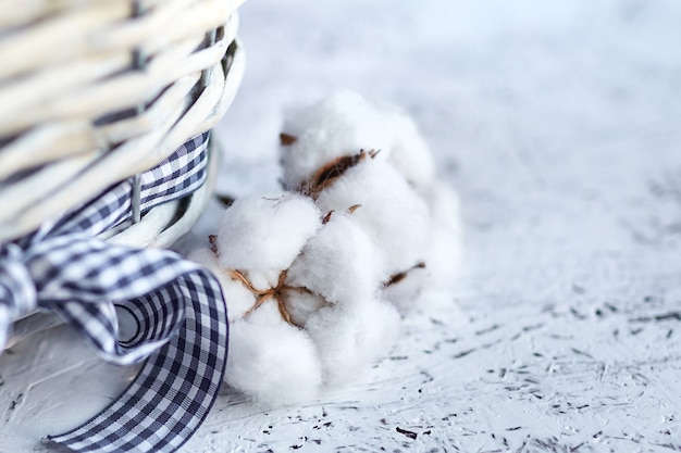 Witte katoenen bloemen met rieten mand op een blauwe houten tafel