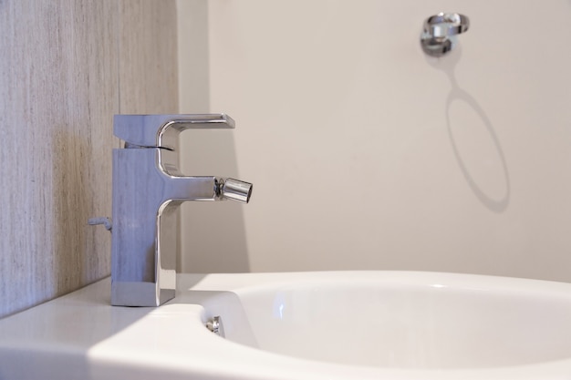 Witte keramische bidet in moderne badkamer.