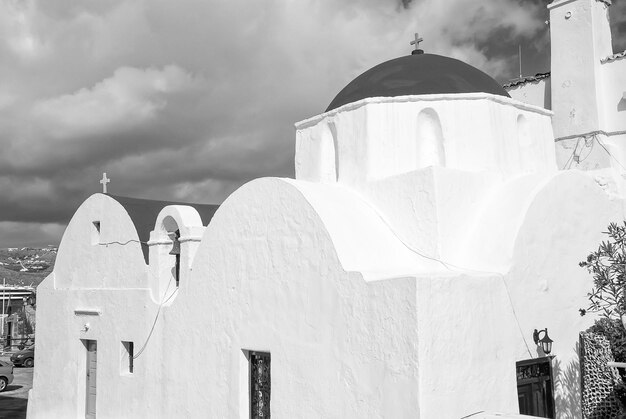 Witte kerk in Mykonos Griekenland Kerk met rode koepel op bewolkte blauwe hemel Kapel gebouw architectuur op zonnige buiten Religie en cultus concept Zomervakantie op mediterrane eiland reislust