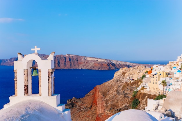 Witte kerkklok en vulkaancaldera met prachtige details van het Eganische zeelandschap van het eiland Santorini, Griekenland