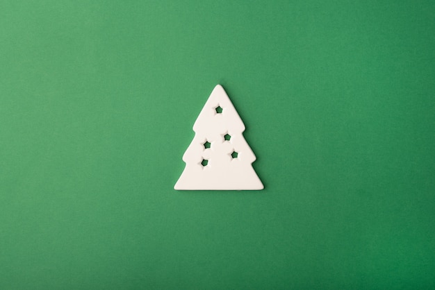 Witte kerstboom gemaakt van keramiek op een diepgroene achtergrond Platliggend bovenaanzicht