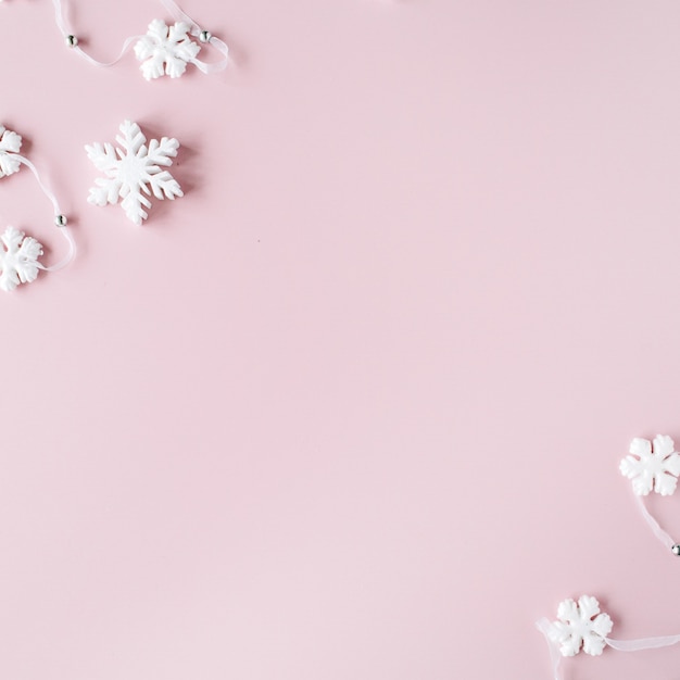 Witte Kerstmissneeuwvlokkendecoratie op roze achtergrond. kerst wallpaper.