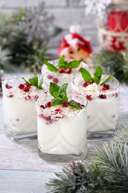 Witte kerstmojito gemaakt van likeur tequila kokosmelk met granaatappelpitjes