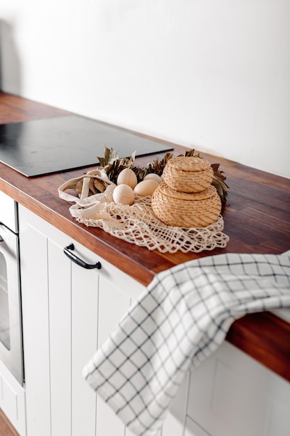 Foto witte keuken met eieren en geschenkdoos vrolijke paaskaart met houten eieren mesh shopper met eieren