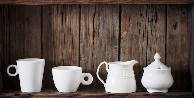 Witte keuken servies op oude donkere houten tafel