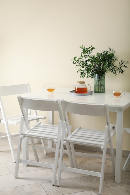 Witte keukentafel met thee en plant in lichte kamer