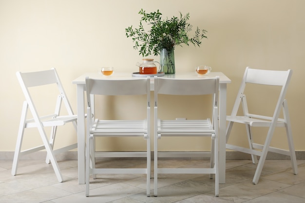 Witte keukentafel met thee en plant in lichte kamer