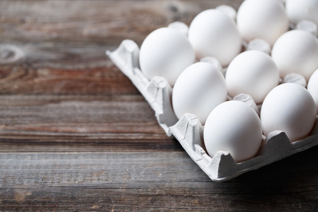 Witte kippeneieren op oude houten tafel