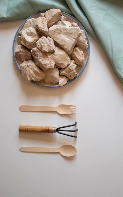 Witte klei stenen met een houten vork lepel en een wrack op een witte achtergrond