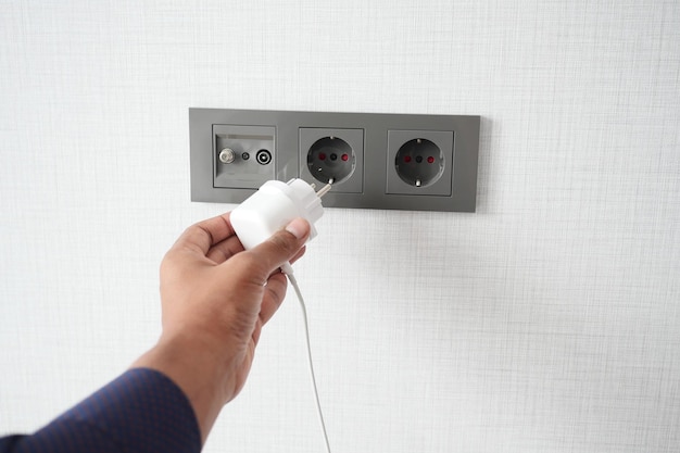 Witte kleur netsnoer kabel aangesloten op de muur