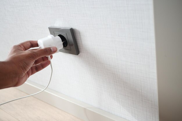 Witte kleur netsnoer kabel aangesloten op de muur