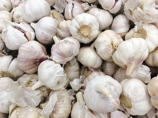 Witte knoflook stapel textuur. Vers knoflook op de close-upfoto van de marktlijst. Het kruidbeeld van het vitamine gezond voedsel.