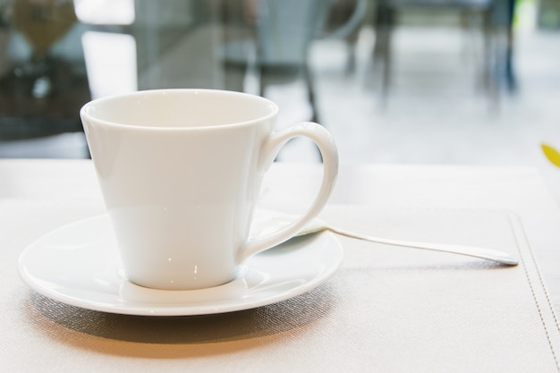 Witte koffiekop op houten tafel in cafe