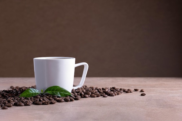 Witte koffiekop staat op bruin oppervlak in de buurt van verspreide koffiebonen