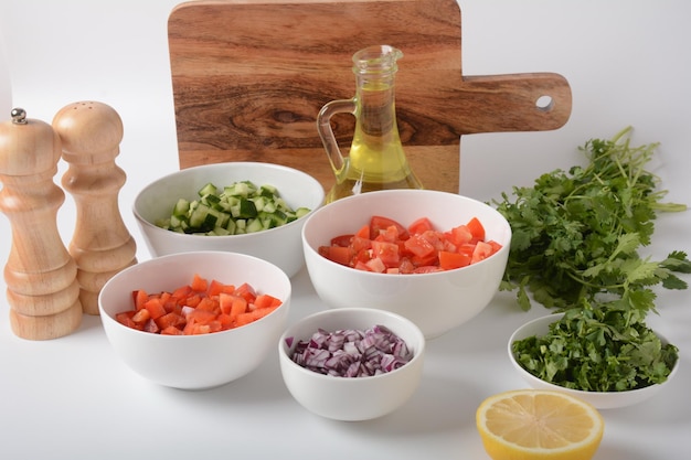 Foto witte kommen met geraspte groenten van verschillende kleuren kookplank met ingrediënten klaar voor de salade