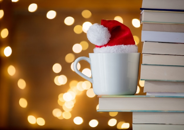 Witte kop en Kerstmishoed dichtbij boeken