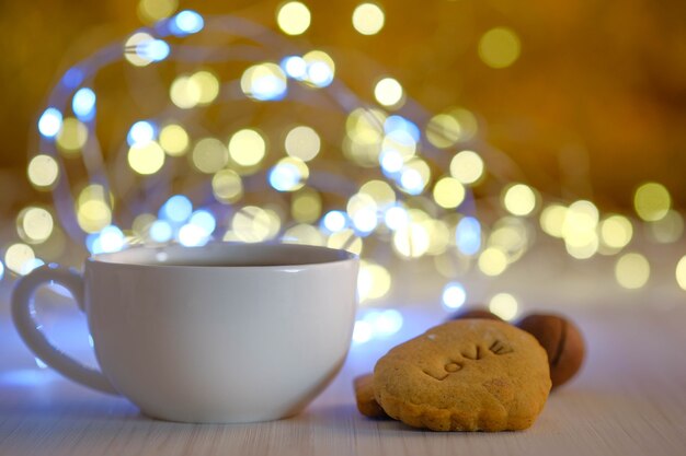 Witte kop en koekjes op een achtergrond van gouden boke