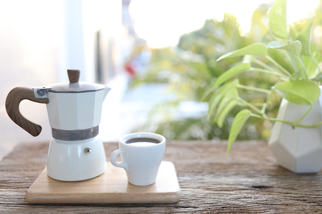 Witte kop en mokapot op houten tafel