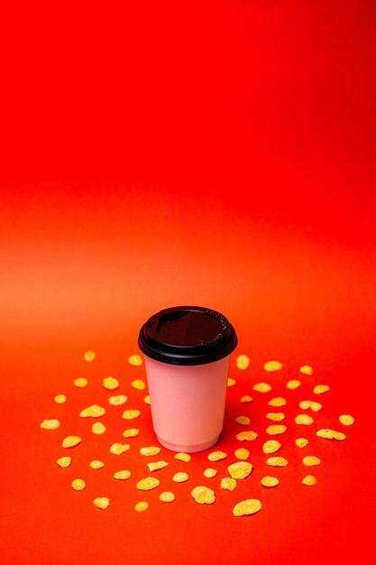 Foto witte kop koffie met granen op een rode achtergrond