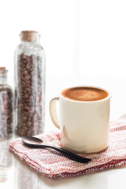 Witte kop koffie op witte tafel met helder