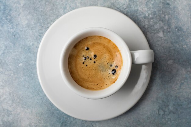 Witte kop met koffie en volle granen Bekijk van bovenaf