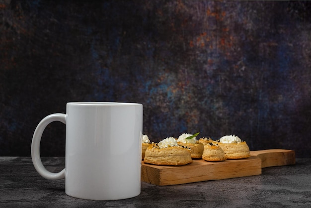 Witte kop met puff pastry rolletjes op de achtergrond op een houten tafel Ontbijtconcept
