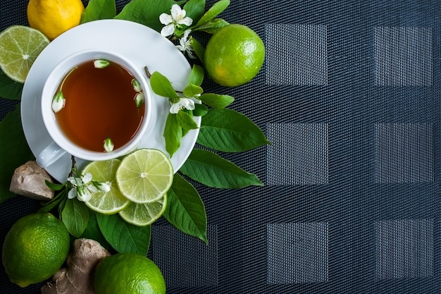 Witte kop met thee Groene zwarte kruidenjasmijnthee met citroen en gember Achtergrond met ruimte voor tekst Theethema