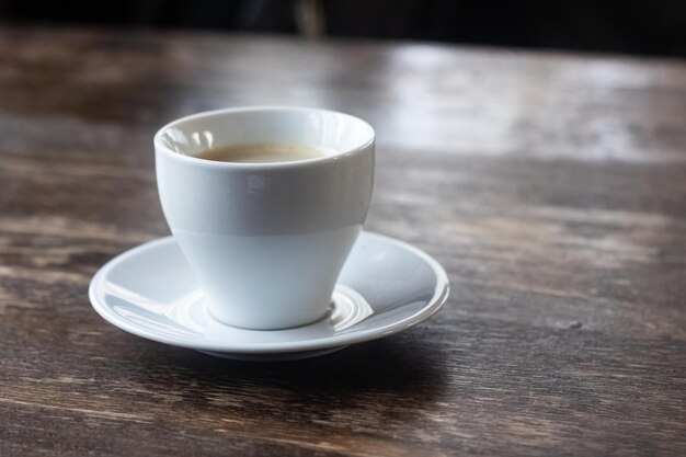 Witte kopje koffie op een houten tafel