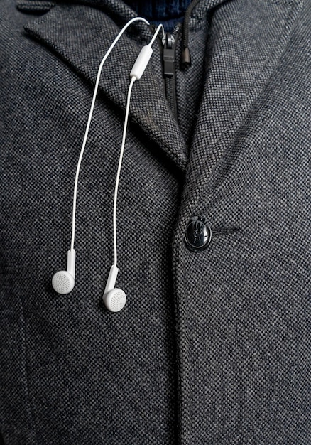 Witte koptelefoon op de achtergrond van een mannenjas close-up