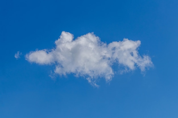 Witte krullende eenzame wolk in de blauwe lucht