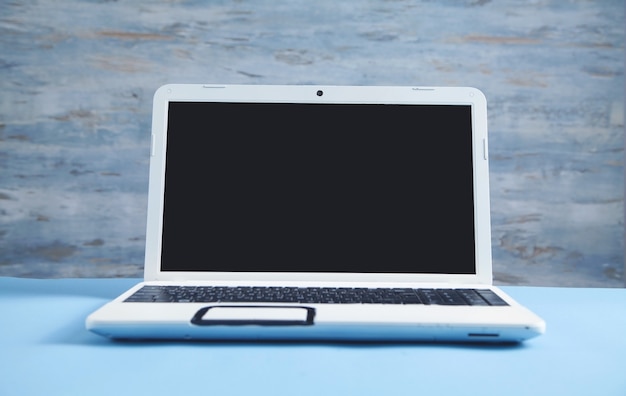 Witte laptop op het blauwe zakelijke bureau.