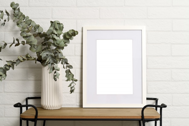 Witte leeg frame op plank met plant in vaas