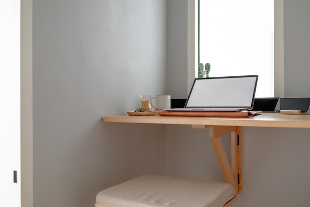 Witte lege beeldscherm laptop op een houten bureau in het appartement.