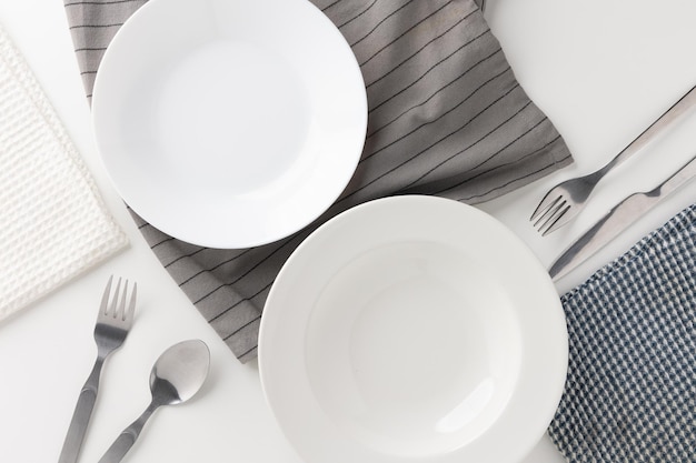 Witte lege borden op tafel met messen en vorken en tafelkleden. Klaar om te eten