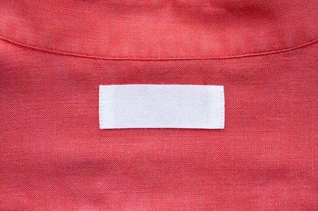 Foto witte lege kleding label label op rode linnen overhemd stof textuur achtergrond