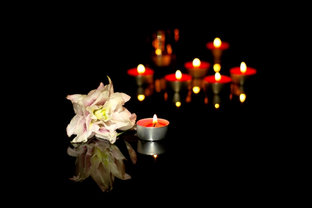 Witte lelie kaarsen van een begrafenis op een plaquette met de reflectie van lichten rouw achtergrond