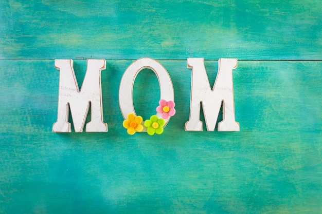 Foto witte letters mom op een geschilderde houten ondergrond.