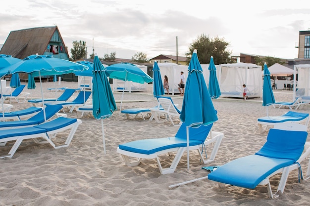 Witte ligstoelen op het zandstrand