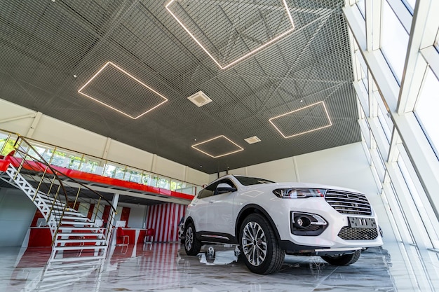 Witte luxe suv staat in autodealer showroom. Verkoop van merkauto's in speciaal centrum. Detailopname.