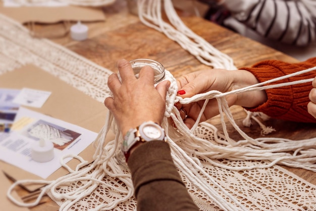 Witte macramé Leraar en leerling werken samen aan de kunst van macramé