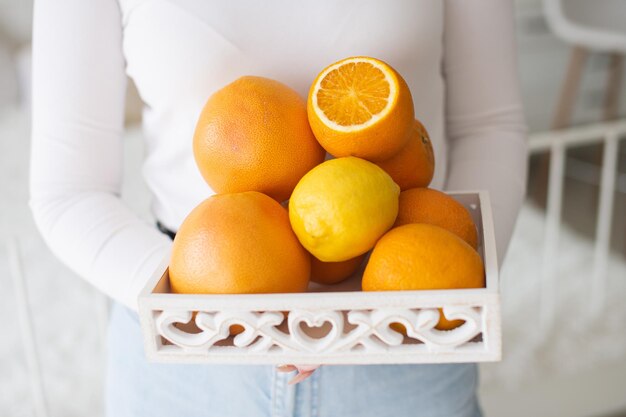 Witte mand met citrusvruchten in de hand