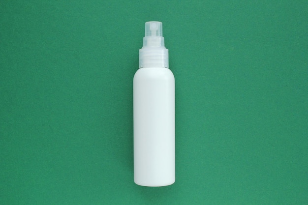 Witte merkloze plastic dispenser spuitfles op groene achtergrond met kopie ruimte voor tekst. cosmetica