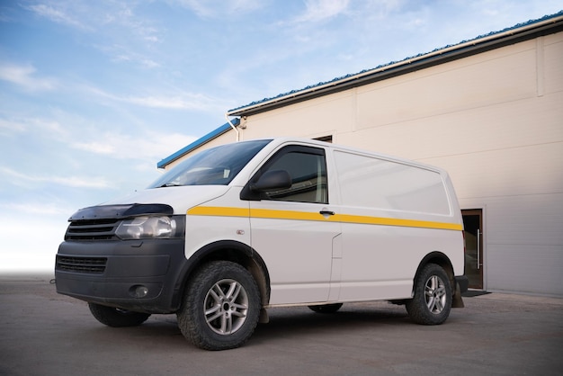 Foto witte minivan in de buurt van het gebouw concept met vrije ruimte