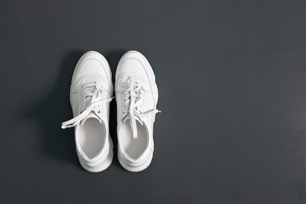 Witte modieuze sneakers voor dames op een grijze ondergrond