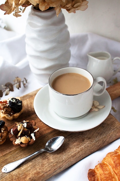 Witte mok met koffie staat op een lichte doek