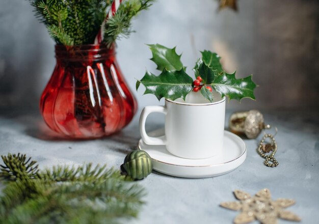 Witte mok op de kersttafel met sparren, bekermodel